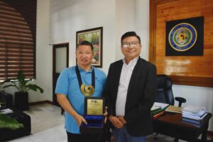 Director of the WVSU Center for Peace Education presents award to President Villaruz