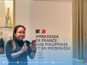 woman holding a microphone on right hand and smartphone in left hand while talking to the audience
