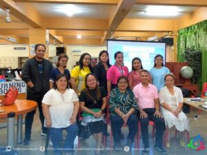 one row of people standing at the back, one row of people seated in front; all facing the camera for a picture