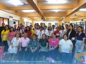 one row of people standing at the back, one row of people seated in front; all facing the camera for a picture